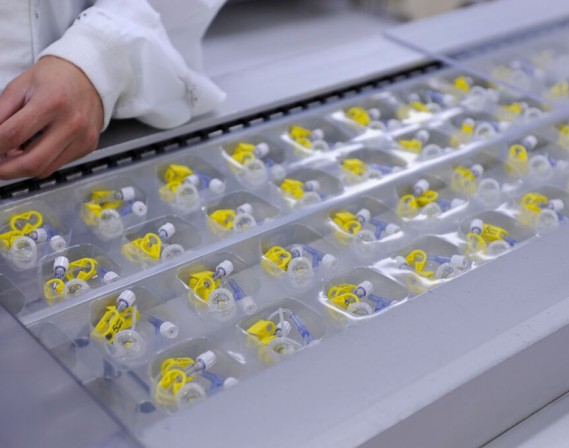 Pods of medical device components on an assembly line.