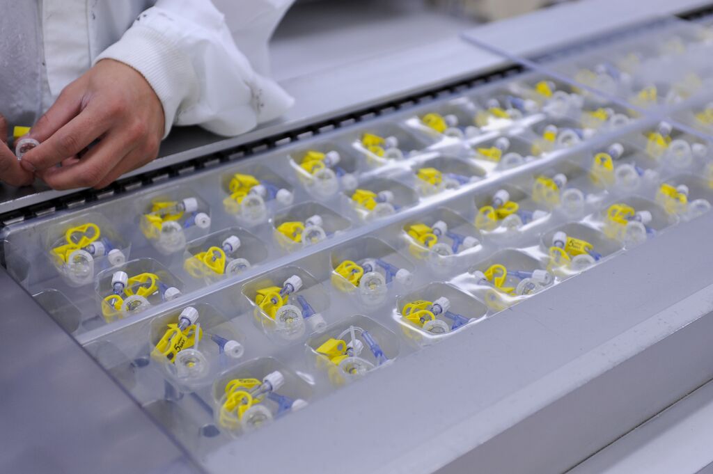 Pods of medical device components on an assembly line.